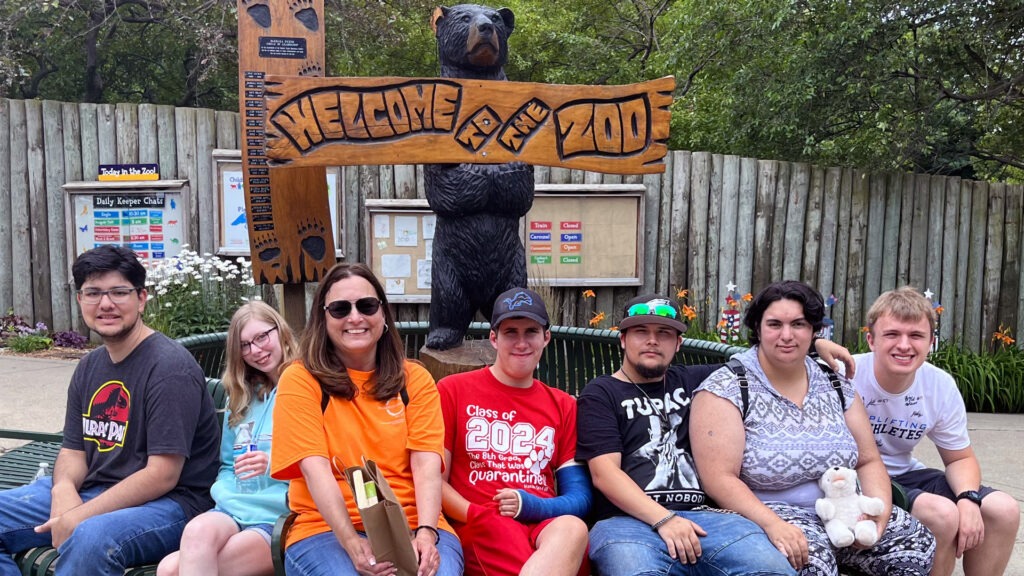 A group of peers sitting on a bench at the Saginaw Zoo